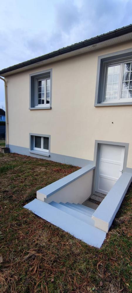Maison couleur crème avec encadrements de fenêtres et descente de sous-sol peints en gris-bleu.