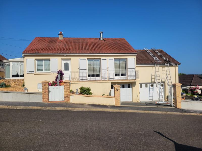 Maison de style pavillon en cours de rénovation avec des échelles contre le mur.