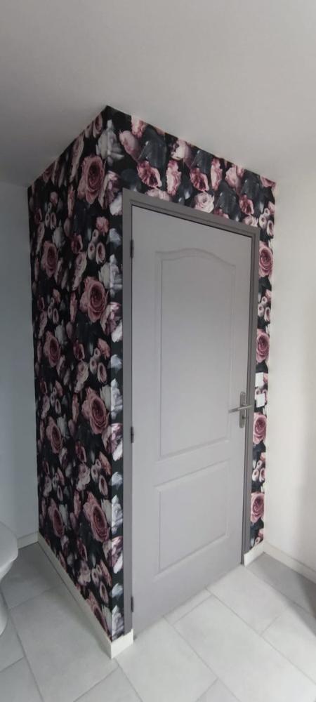 Entrée avec papier peint floral rose et noir autour d'une porte blanche moderne