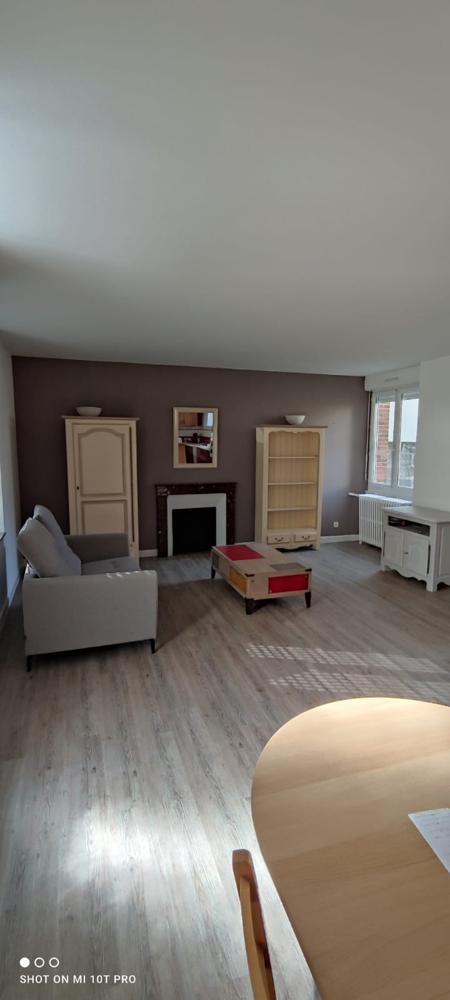 Salon moderne avec mur accent gris anthracite, meubles en bois clair et parquet stratifié