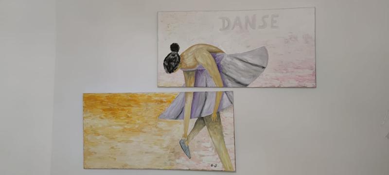 Deux tableaux sur un mur blanc. L'un représente la partie supérieure d'une ballerine se penchant en avant et l'autre la partie inférieure de ses jambes et de son pied. Le mot 'DANSE' est écrit au-dessus.