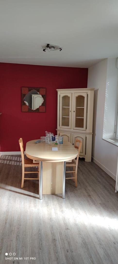 Salle à manger avec mur rouge bordeaux, meuble vaisselier crème et parquet gris