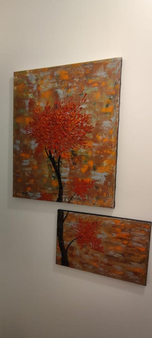 Deux tableaux, un grand et un petit, représentant un arbre avec des feuilles rouge vif et orange et un tronc noir sur un fond texturé d'argent, d'orange et de gris.