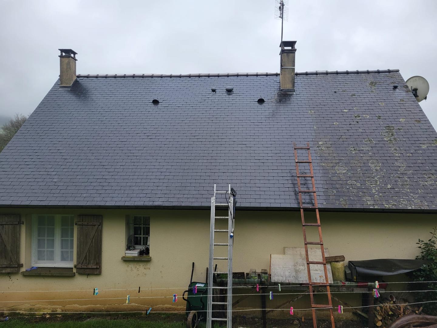 Toiture en ardoise avec de la mousse et du lichen avant le début des travaux de nettoyage.